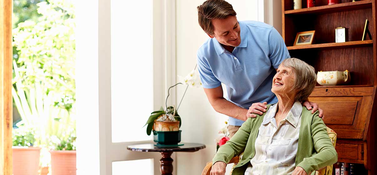 Una enfermera ayudando a un hombre de la tercera edad