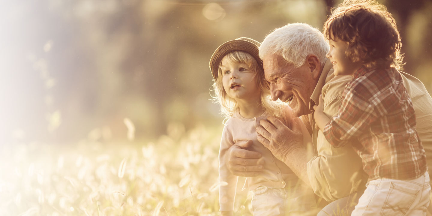 Older gentleman playing outdoors with grandkids