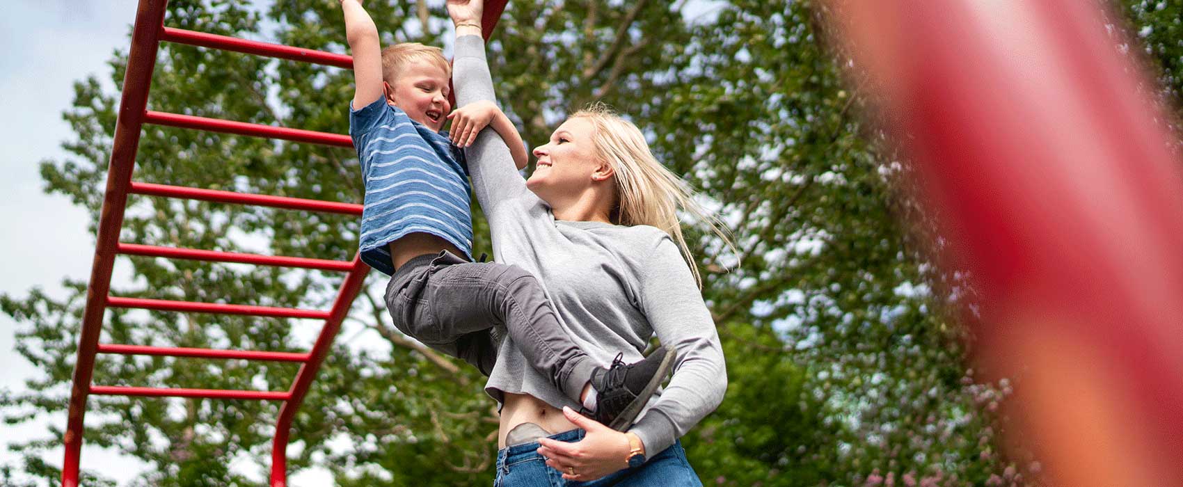mother playing with son on monkeybars