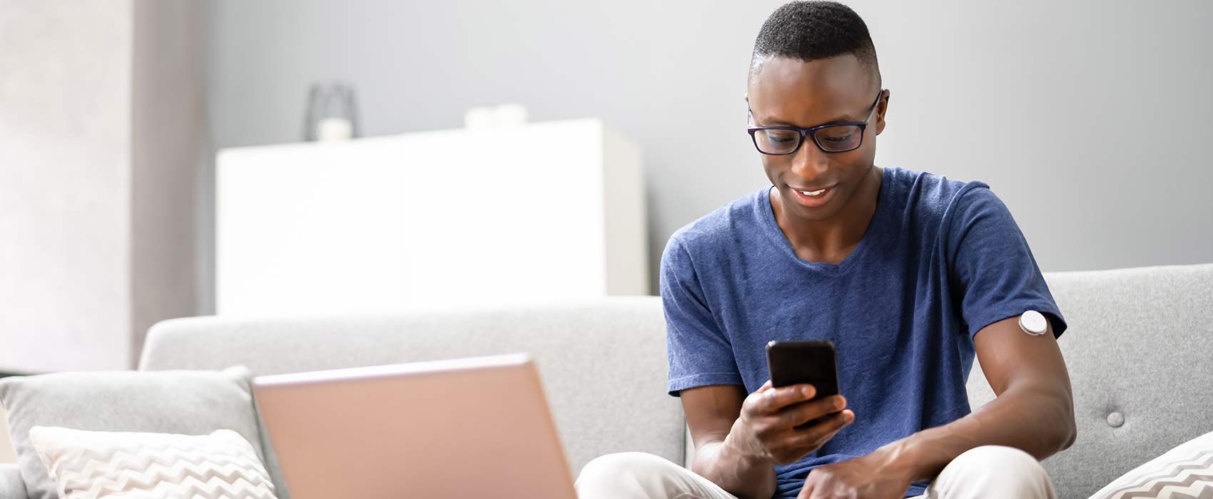 man on couch looking at phone
