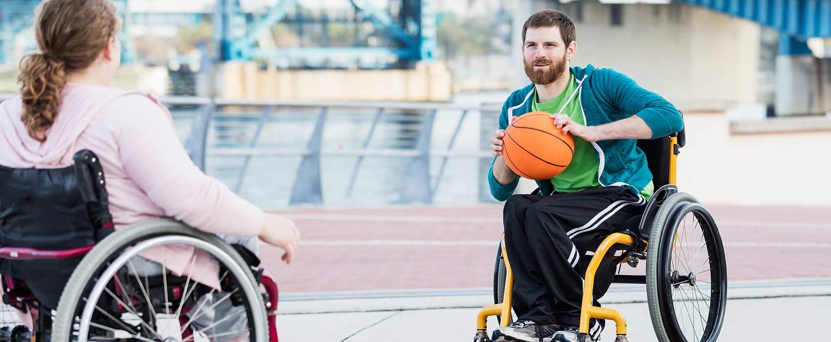 man woman playing basketball in wheelchairs