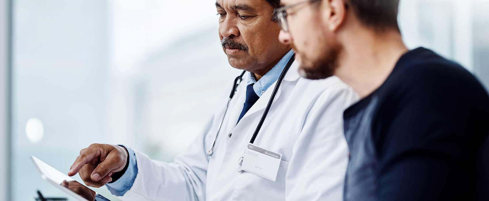 Male doctor going over chart with male patient
