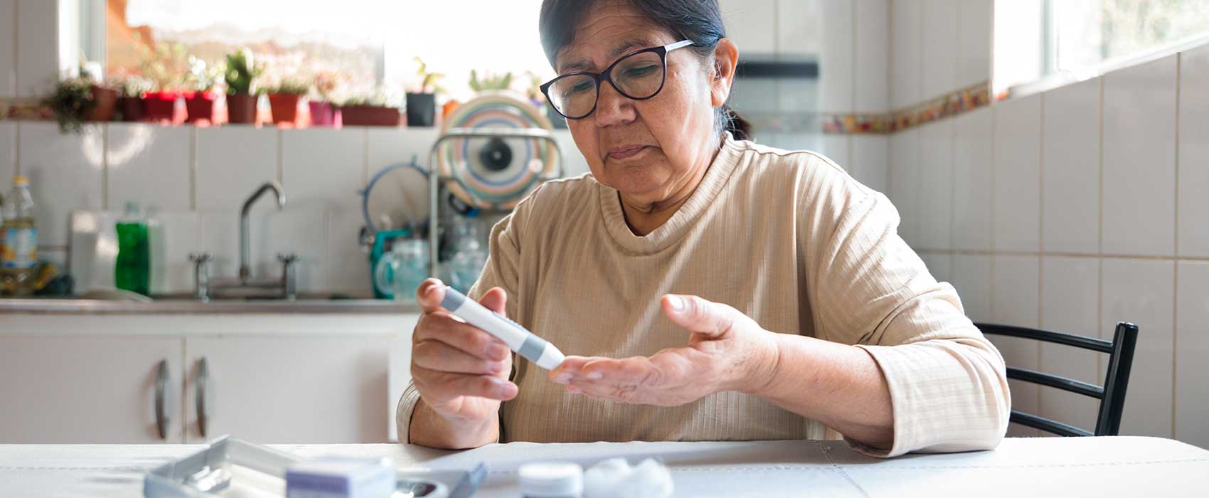 woman in kitchen testing blood sugar
