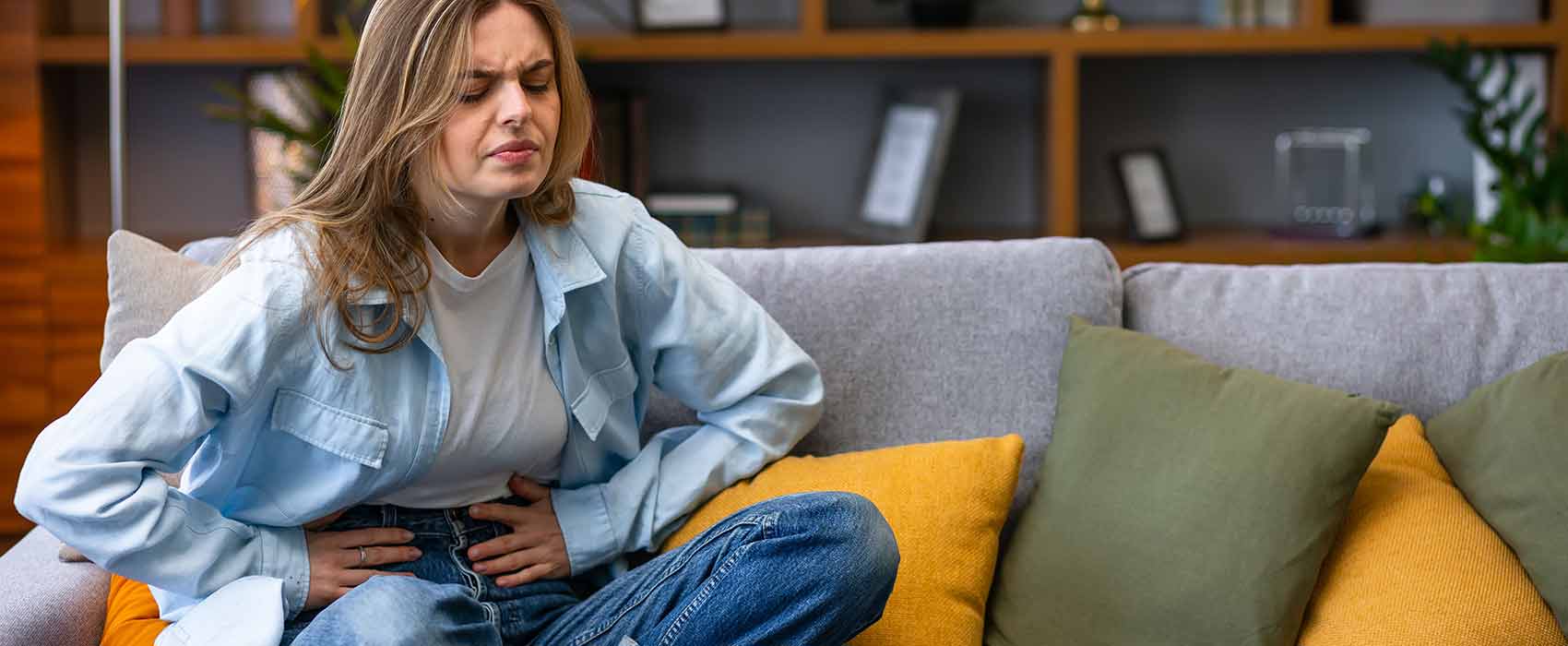 woman on couch in discomfort