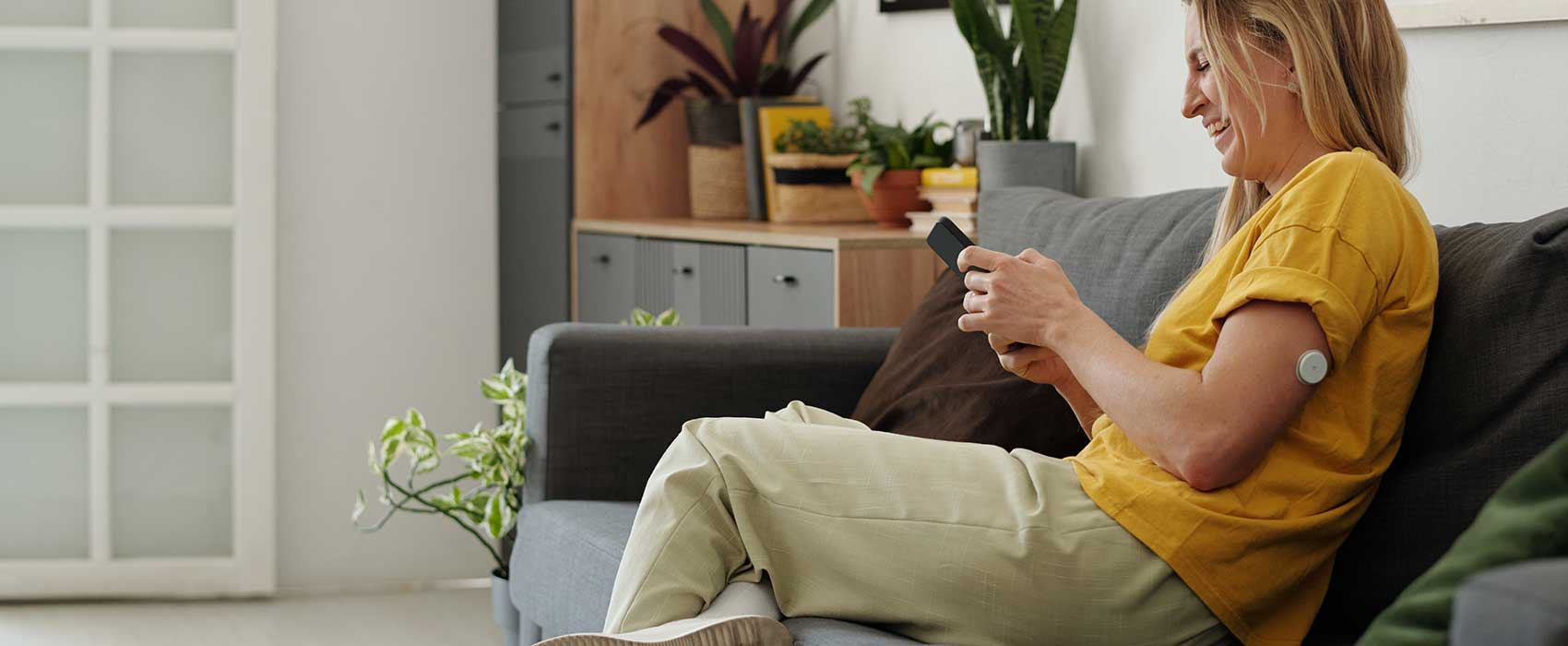 woman on couch and phone with cgm