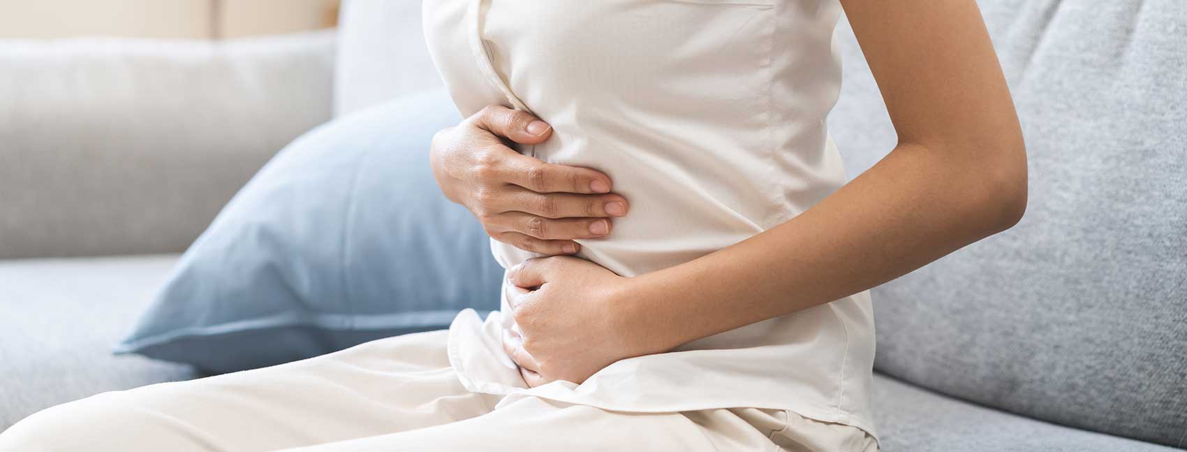 women with lower abdominal pain on couch